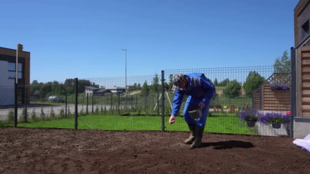 熟練した造園家が一握りの草の種を撒き散らして — ストック動画