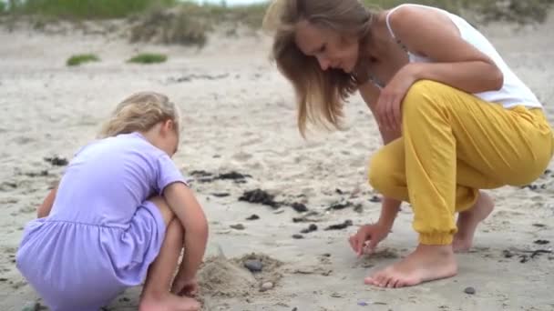 Mãe caucasiana e menina filha construir castelo de pedras de seixos de areia — Vídeo de Stock