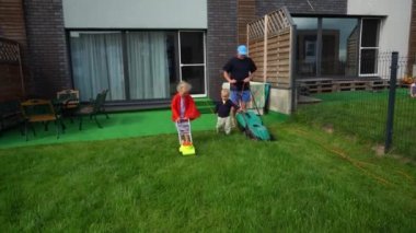 Baba oğul çim biçer ve süper kız kız kız pelerin ve çim biçme makinesiyle