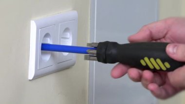 Elektrikçi eliyle prizleri kuruyor.