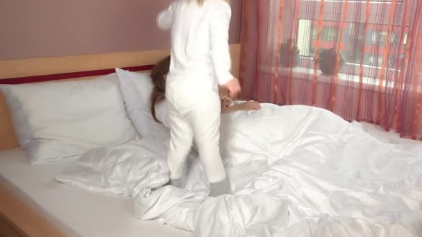 Mädchen hält ihre Mutter vom Einschlafen ab und weckt sie im Schlafzimmer. 4K — Stockvideo