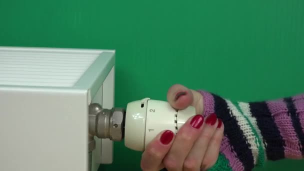 손톱으로 여성은 배경에서 라디에이터의 온도를 조절하고 있습니다 — 비디오