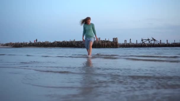 Активная Женщина Одежде Бродит Морской Воде Возле Старого Заброшенного Пирса — стоковое видео
