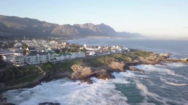 Kayalık bir sahil şeridinde ve dalgaları kırılan küçük bir kasabada.