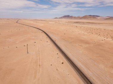 Çölde ilerleyen demiryolu raylarının üzerindeki havadan.