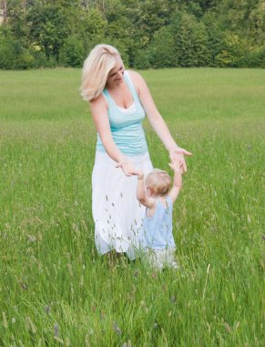 güzel anne küçük oğlu ile çayır üzerinde oynama.