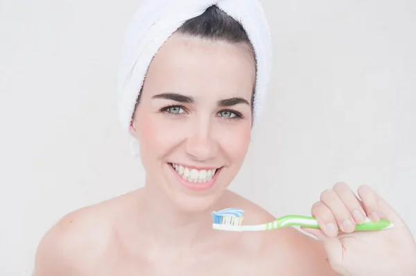 Mujer joven sonriente con hermosos dientes sanos sosteniendo un cepillo de dientes — Foto de Stock