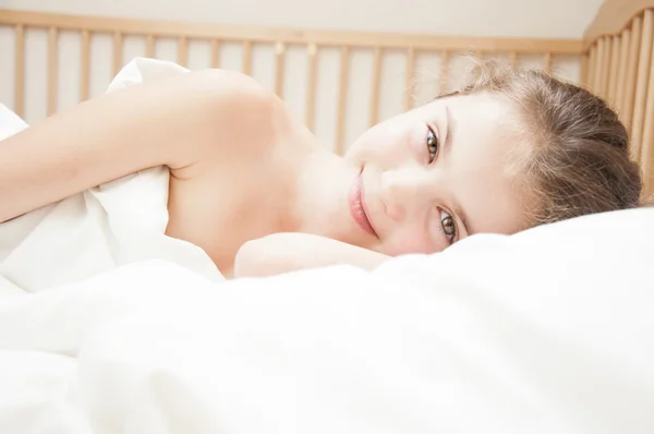 Niedlich gerade erwachtes Mädchen im Bett. — Stockfoto