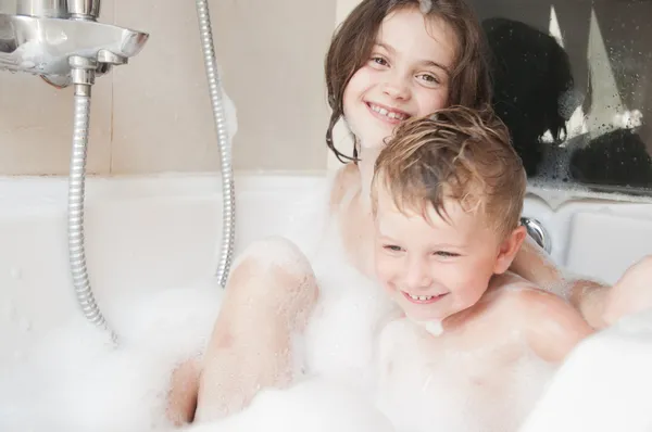 Hermano y hermana tomando un baño de burbujas  . — Foto de Stock