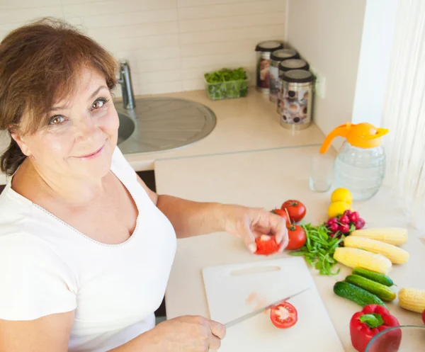 Oudere vrouw in keuken bereiden van gezond voedsel — Stockfoto