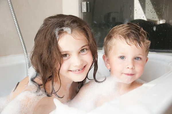 Irmão e irmã tomando um banho de espuma — Fotografia de Stock