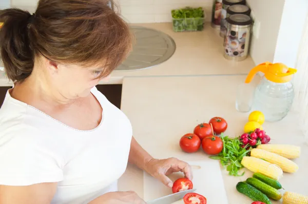 Oudere vrouw in keuken bereiden van gezond voedsel — Stockfoto
