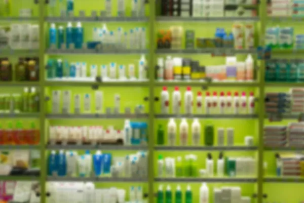 Filas de imagen borrosa de productos para el cuidado del cabello en exhibición en la tienda. Productos cosméticos en venta en la tienda de belleza fondo abstracto . —  Fotos de Stock