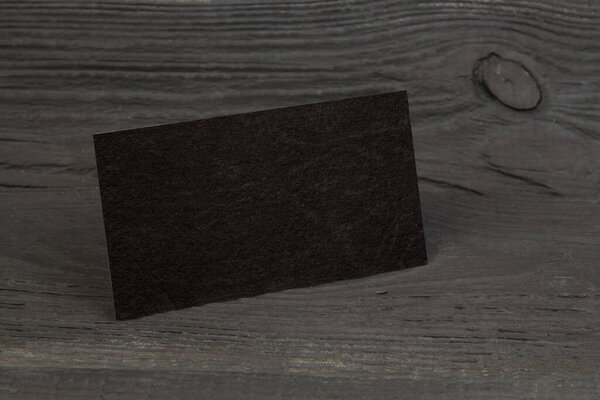 Чистые визитки на черном деревянном столе. Шаблон для идентификации. Вид сверху
