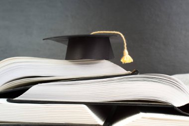 Ahşap güverte masası ve kara tahta arka planı üzerine açık bir kitap. Okula geri dön. Reklam metnin için kopyalama alanı olan eğitim kavramı