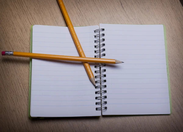 Cuaderno abierto sobre un escritorio de madera con lápiz — Foto de Stock