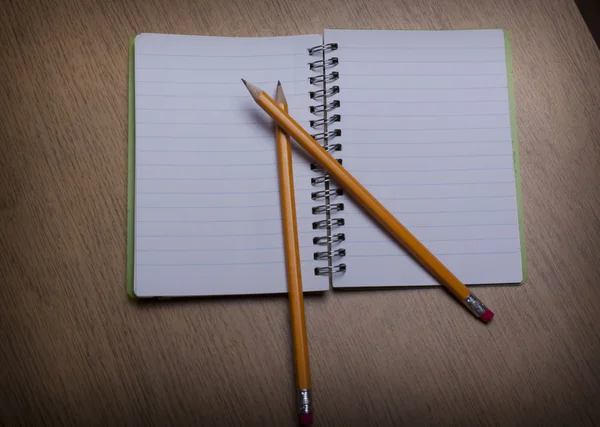 ahşap masa üstünde defter kalem ile açın