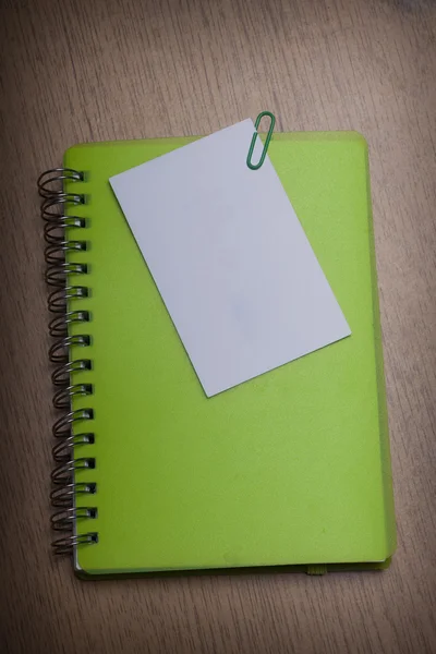 Πράσινο σημειωματάριο σε ένα ξύλινο γραφείο — Φωτογραφία Αρχείου