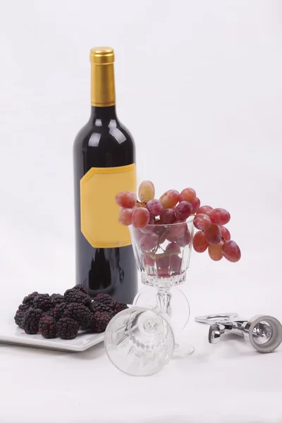 Bouteille de vin rouge et verre rempli de raisins — Photo