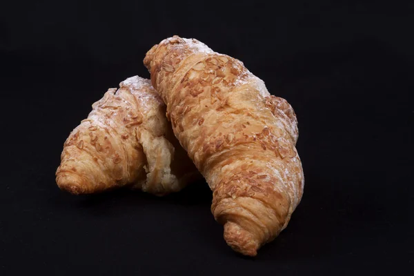 Croissant fresco su fondo nero — Foto Stock