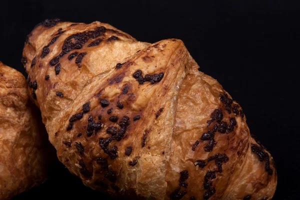 Frisches Schoko-Croissant auf schwarzem Hintergrund — Stockfoto