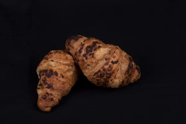 Croissant de chocolate fresco em um fundo preto — Fotografia de Stock