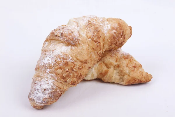 Croissant de amêndoa fresca em um fundo branco — Fotografia de Stock