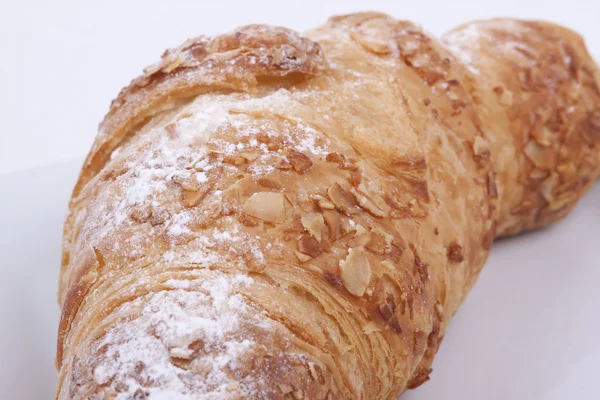 Croissant de almendras frescas sobre un fondo blanco —  Fotos de Stock