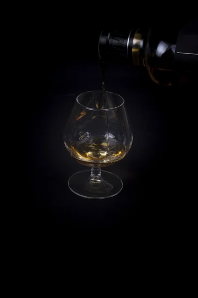 Versare il cognac in un bicchiere . — Foto Stock