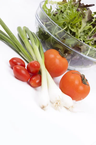 Salade, tomaten, lente-uitjes en oranje peper geïsoleerd op whi — Stockfoto