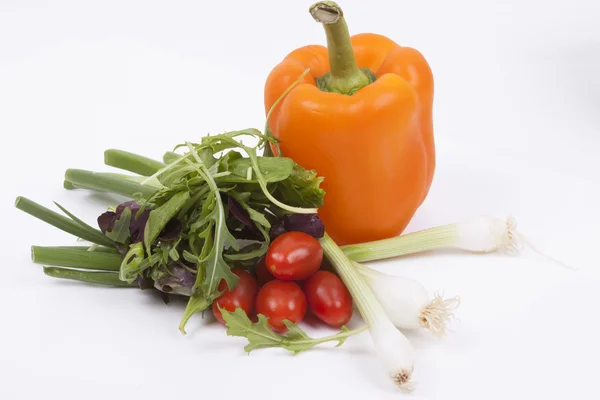 Salade, tomaten, lente-uitjes en oranje peper geïsoleerd op whi — Stockfoto