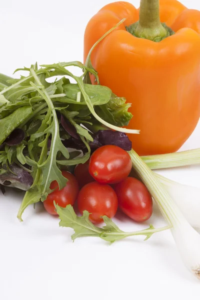 Salade, tomaten, lente-uitjes en oranje peper geïsoleerd op whi — Stockfoto
