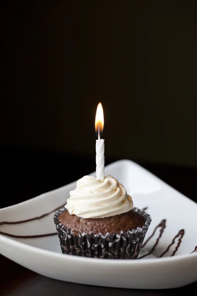 Pastel de chocolate con una vela de cumpleaños ardiente — Foto de Stock