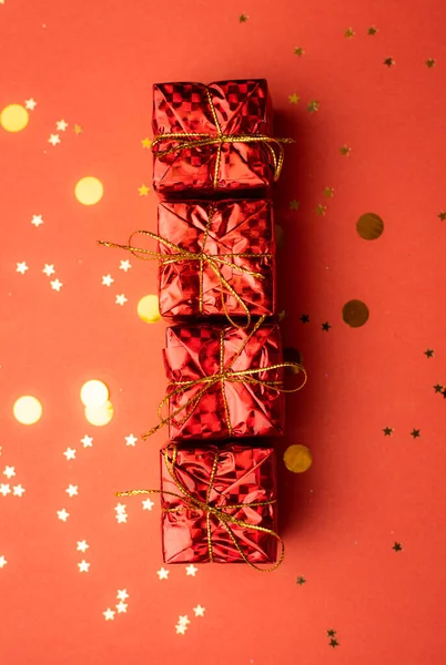 Röda julklappar och julgranar på en röd bakgrund. En artikel om det nya året och julen. Valet av gåvor. En röd gåva . — Stockfoto