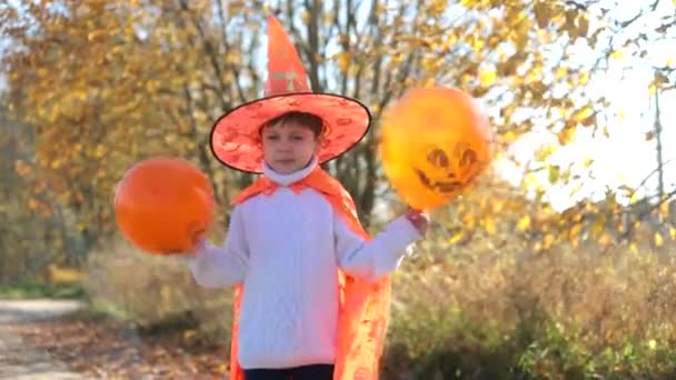 Un garçon en costume d'Halloween avec des ballons. Portrait d'un garçon avec ballons. Le sourire d'un enfant. Vacances d'Halloween. — Video