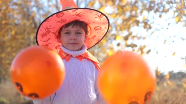 Chłopiec w kostiumie halloweenowym z balonami. Portret chłopca z balonami. Uśmiech dziecka. Święto Halloween. — Wideo stockowe