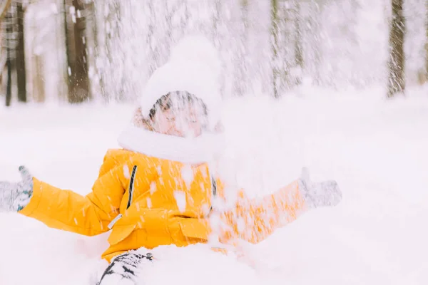 Le garçon jette de la neige dans le mode de vie hivernal. Promenades hivernales. Un article sur les loisirs d'hiver des enfants. — Photo