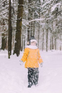 Çocuk kış yaşam tarzında kar atıyor. Kış yürüyüşleri. Çocukların kış tatili hakkında bir makale. Eğlenceler