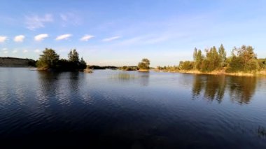 Water in the quarry in summer in the evening light . A living natural picture. Flooded quarry. Summer