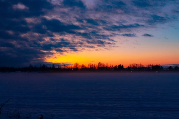 Wintersonnenuntergang auf dem Feld. Winterlandschaft. — Stockfoto