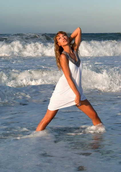 Mujer vestida de blanco posando en la costa del mar — Foto de Stock