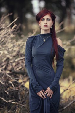 ormanda uzun mavi elbiseli kızıl saçlı kız
