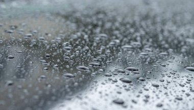 Arabanın yüzeyinde yağmur damlaları var.