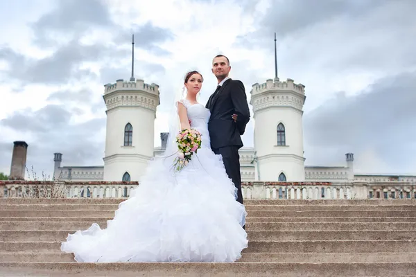 Bride and groom posing near castle — Stock Photo, Image