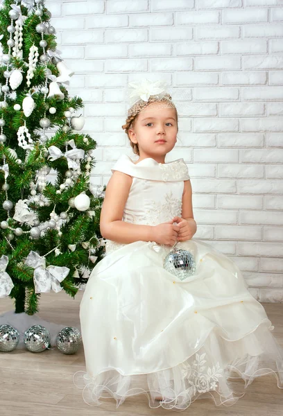 Красивая маленькая девочка возле новогодней елки — стоковое фото