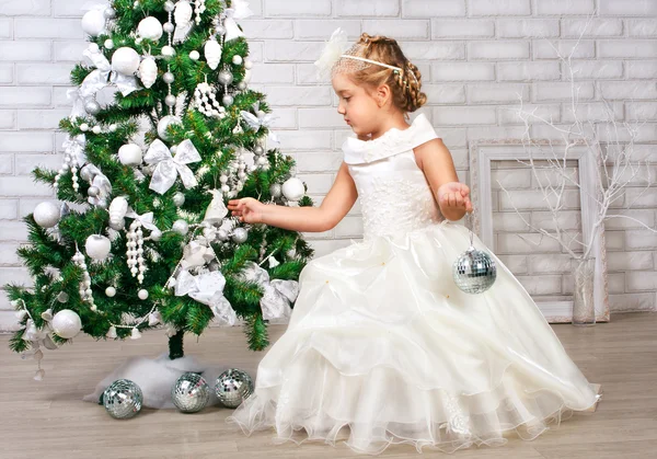 Досить маленька дівчинка біля новорічної ялинки — стокове фото
