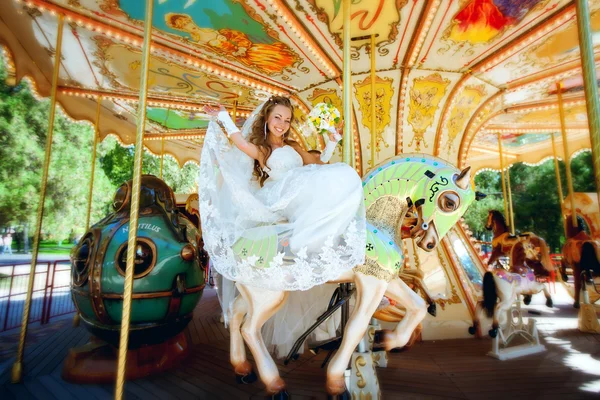 Красива наречена катається на каруселі — стокове фото