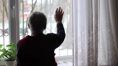 Yaşlı kadın, büyükanne elini camdan dışarı sallıyor..