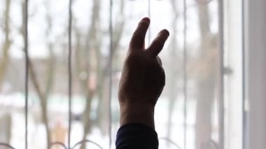 Yaşlı bir kadın elini kaldırır ve iki parmaklı bir işaret gösterir..