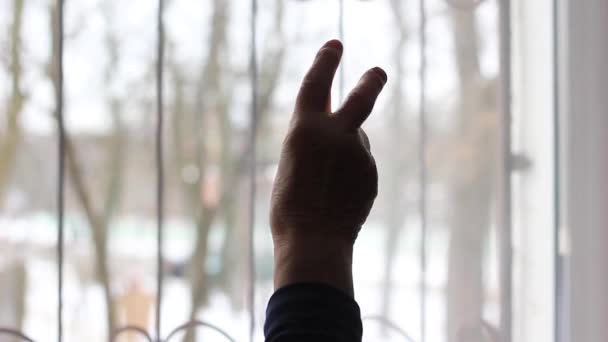 An elderly womans hand is raised up and shows a sign with two fingers. — Stockvideo